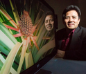 Biologist Ray Ming next to a screen showing a plan