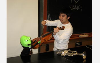 Photo of Ryan Miyakawa warming up the orchestra before recording The Nano Song.