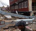 people next to rubble from a house damaged by earthquake