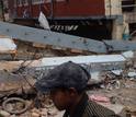 man by rubble and damaged houses after the April 2015 earthquake in Nepal