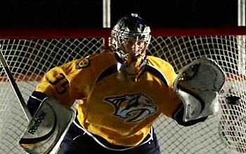 Hockey goalie about to grab a puck