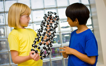 Photo of children talking about a model of a carbon nanotube.