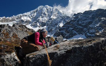 Photo of University of New Hampshire graduate student Jean Taggart chiseling a sample of a boulder.