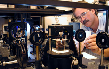 Steve Hegwer inserts a white card into the light path of Dunn's high-order adaptive optics system