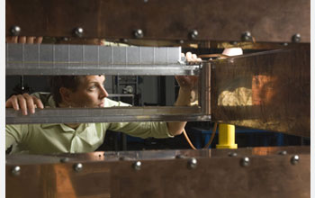 Photo of Matt Johnson, NSCL staff engineer, inspecting a 45-degree dipole magnet