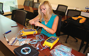 A technician tests fiber optic equipment