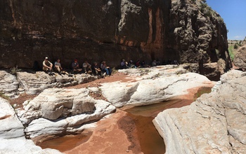 A group of scientists sitting on rocks at Cibola Canyon, N.M., in NSF's Sevilleta Long-Term Ecological Research site.