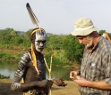 Frank Brown and a Mursi warrior examine a sample of colored rock.