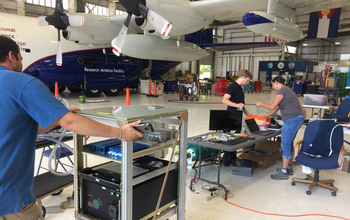 Scientists loading measurement instrumentation aboard the NSF C-130 aircraft.