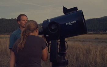 portable telescope in a field with researchers