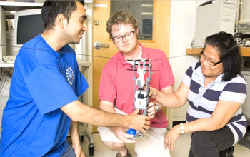 three people with a device working in a lab