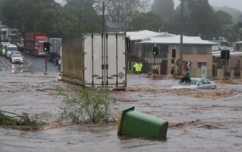 A woman in Australia awaits rescue on a car roof.