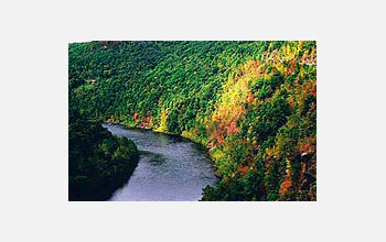 Photo of a river crossing forested hills.