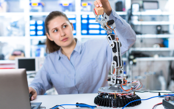 Woman in a laboratory experimenting with a robot