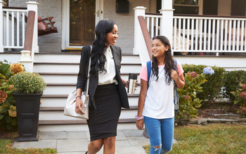 Woman and child walk away from a front porch, smiling and talking to each other.