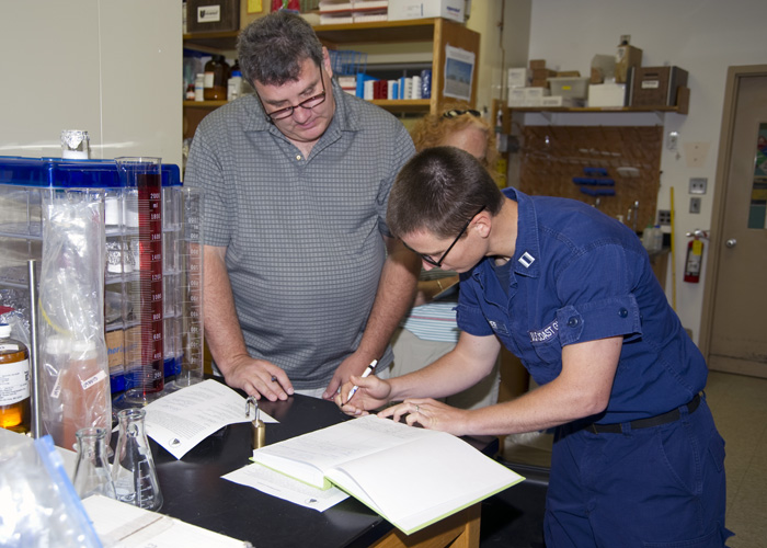 two people preparing the Gulf sample to take to Woods Hole Oceanographic Institution.
