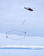 Photo of a helicopter deploying SkyTem mapping technology in Antarctica.