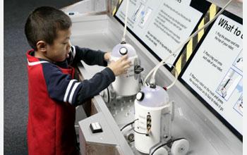 Young boy learning about  fantasy and real-world robots so he can then try building a droid.