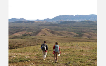 Photo showing Laura Poppick and Blake Dyer hiking down a stromatolite reef in South Australia.