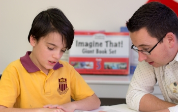 student and teacher sitting at table