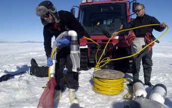 Deploying a siphon into a dive hole just off McMurdo Station, Antarctica