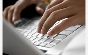 Photo of hands on a keyboard.