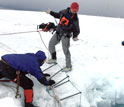 Three scientist perform a crevasse search-and-rescue drill