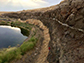 base of a cliff that shows a layer of grey volcanic ash, found between two basalt flows,