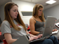 two students working on laptops