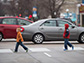 two kids crossing a busy road