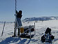 researcher sitting out microphones in the foothills of Alaska's Brooks Range