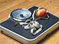 a scale with a tape measure and an apple on it