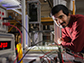 researcher Balachandra Suri leans over a device that triggers turbulent flows