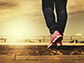 a persons legs walking on a beach pier