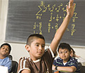 Photo of youngster raising his hand in classroom setting
