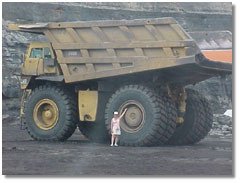 a teacher from Mississippi looks at a large dump truck; caption is below